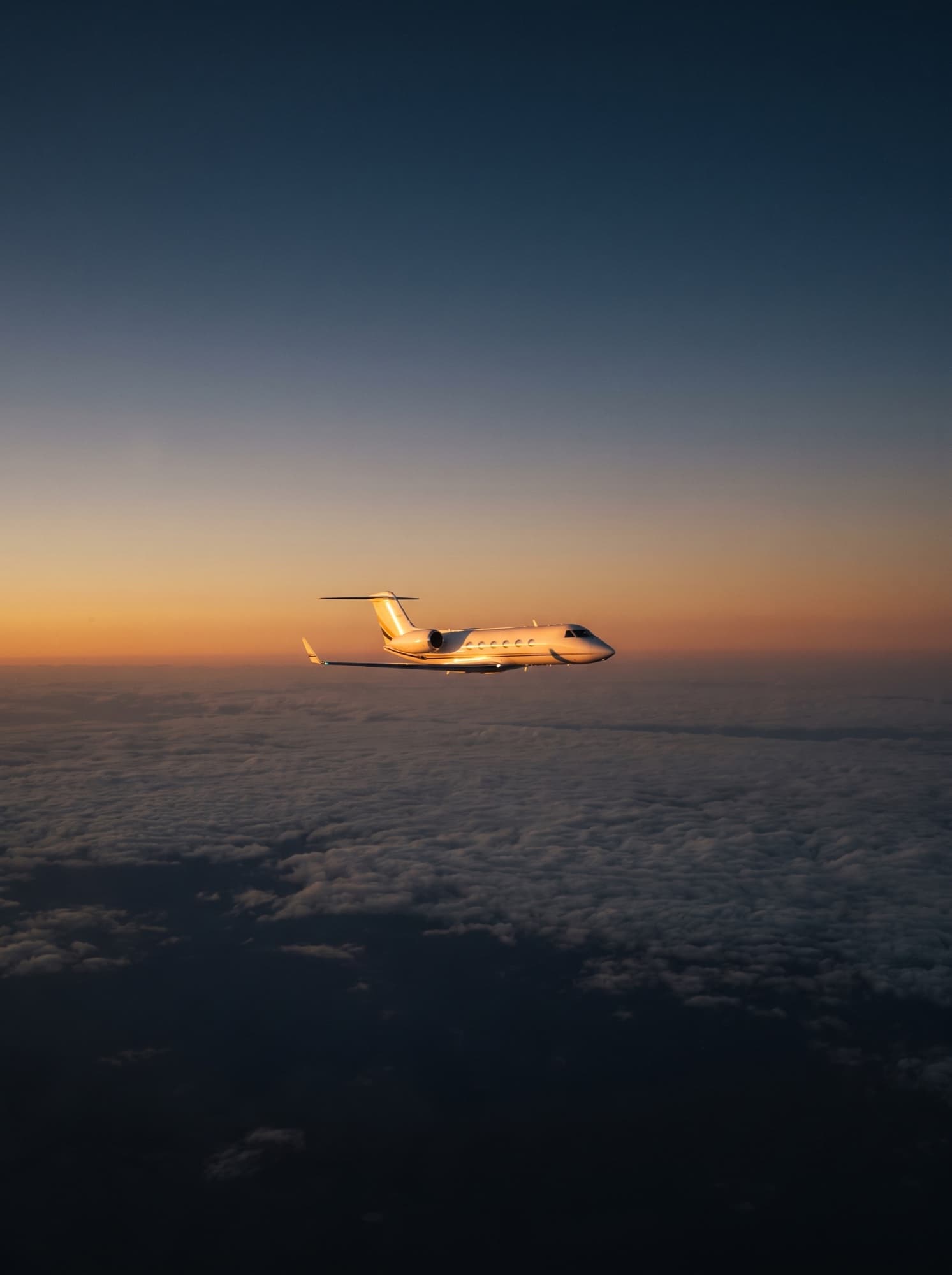 Avion privé en vol au-dessus des nuages, au coucher du soleil